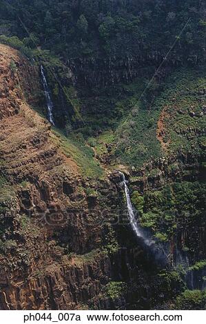 Stock Image - USA, Hawaii, Kauai, Waterfall and mountain range. Fotosearch