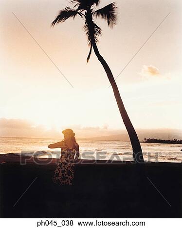 Stock Photo - Silhouette of a female hula dancing outdoors at sunset. . Fotosearch