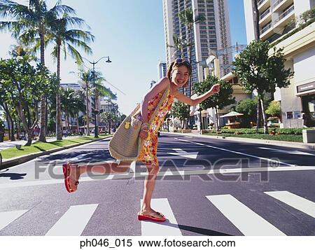 Stock Photography - Young woman crossing street, Hawaii. Fotosearch