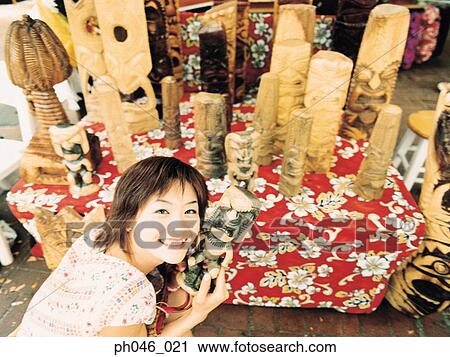 Young woman holding Hawaiian handicraft, smiling View Large Photo Image Stock Image - Young woman holding Hawaiian handicraft, smiling. Fotosearch