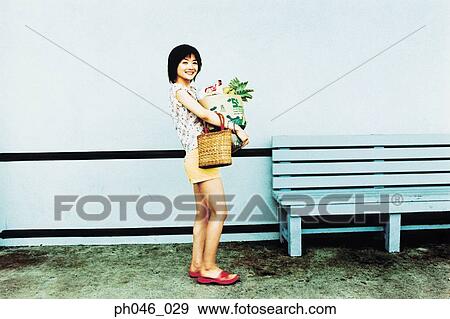 Stock Photo - Young woman holding shopping bag . Fotosearch