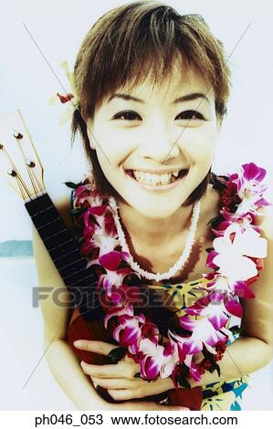 Young woman in Hawaiian blouse holding ukulele View Large Photo Image Stock Image - Young woman in Hawaiian blouse holding ukulele . Fotosearch