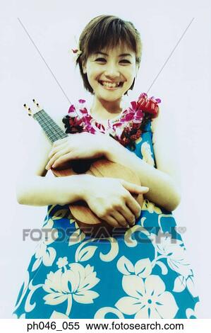Stock Photography - Young woman in Hawaiian blouse holding ukulele . Fotosearch