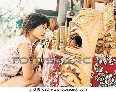 Young woman looking at Hawaiian handicraft View Large Photo Image Stock Image - Young woman looking at Hawaiian handicraft. Fotosearch