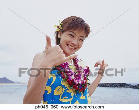 Stock Image - Young woman posing in Hawaiian blouse and garland. Fotosearch