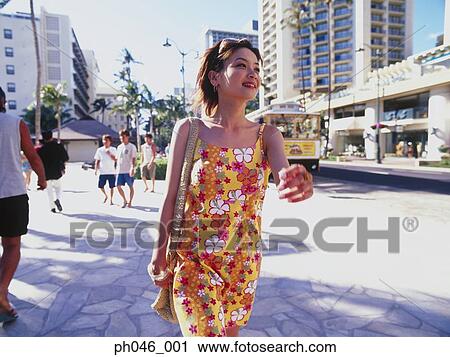 Stock Image - Young woman walking streets of Hawaii. Fotosearch