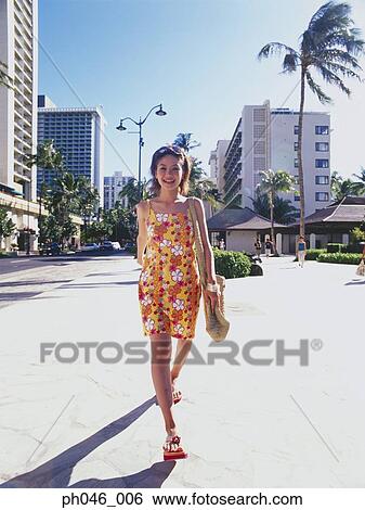 Stock Photograph - Young woman walking streets of Hawaii. Fotosearch