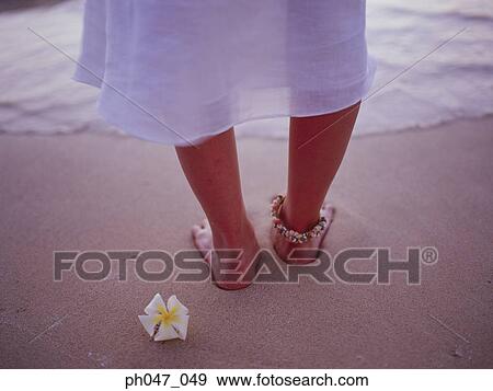 Stock Photo - Close-up of a woman's leg, standing in sand. . Fotosearch