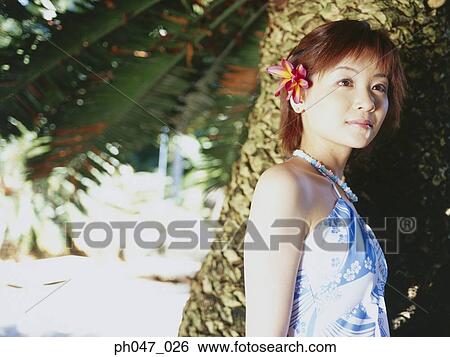 Stock Photograph - Portrait of young woman in Hawaiian blouse. Fotosearch