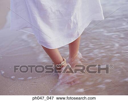 Woman standing in wet sand, low section View Large Photo Image Stock Photo - Woman standing in wet sand, low section . Fotosearch