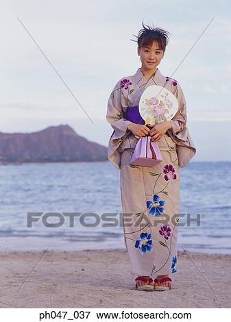 Stock Photo - Young woman in Japanese kimono at a beach, portrait. Fotosearch