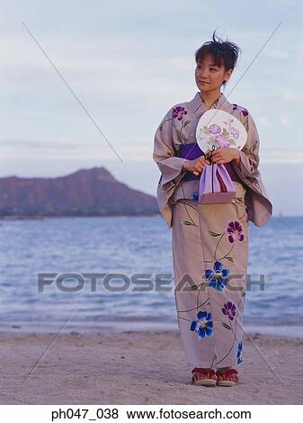 Stock Photo - Young woman in Japanese kimono at a beach, portrait. Fotosearch