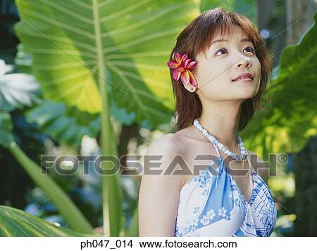 Picture - Young woman posing in Hawaiian blouse. Fotosearch