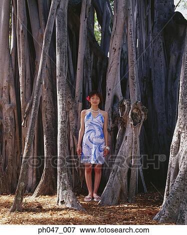 Young woman standing in front of old growth tree View Large Photo Image Stock Photo - Young woman standing in front of old growth tree. Fotosearch
