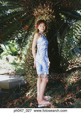 Young woman standing in front of palm tree View Large Photo Image Stock Photo - Young woman standing in front of palm tree. Fotosearch