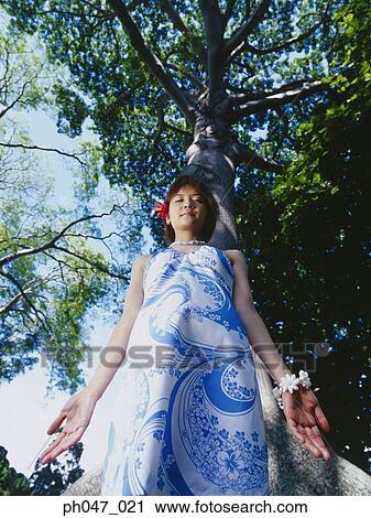 Young woman standing in Hawaiian blouse, low angle view View Large Photo Image Stock Image - Young woman standing in Hawaiian blouse, low angle view . Fotosearch