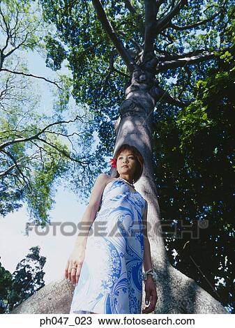 Young woman standing in Hawaiian blouse, low angle view View Large Photo Image Stock Image - Young woman standing in Hawaiian blouse, low angle view . Fotosearch