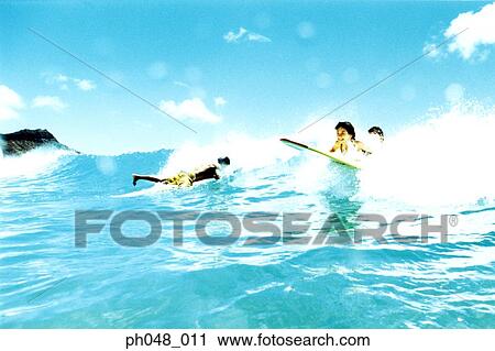 Surfers on surfboard in breaking wave View Large Photo Image Stock Image - Surfers on surfboard in breaking wave . Fotosearch