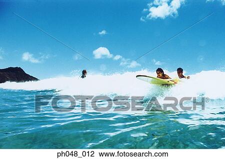 Surfers on surfboard in breaking wave View Large Photo Image Stock Image - Surfers on surfboard in breaking wave . Fotosearch