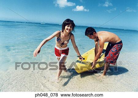 Young couple pulling kayak to shore View Large Photo Image Stock Photo - Young couple pulling kayak to shore. Fotosearch