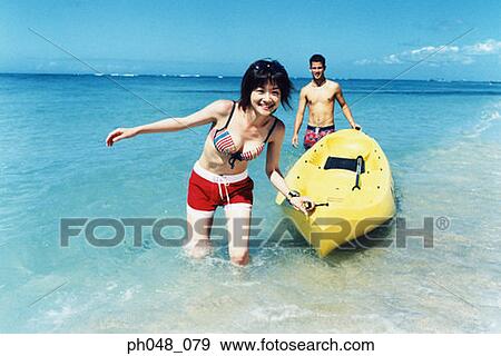 Young couple pulling kayak to shore View Large Photo Image Stock Photo - Young couple pulling kayak to shore. Fotosearch