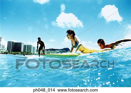 Picture - Young couple surfing, Hawaii beach. Fotosearch