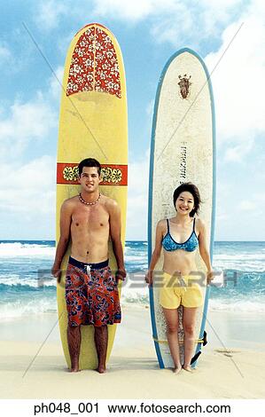 Young man and woman at a beach with surfboards View Large Photo Image Stock Image - Young man and woman at a beach with surfboards . Fotosearch