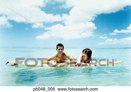 Young man and woman on surfboard in water View Large Photo Image Stock Photography - Young man and woman on surfboard in water . Fotosearch