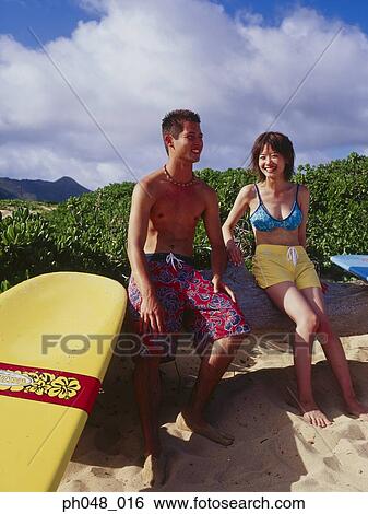 Young man and woman sitting on surfboard View Large Photo Image Stock Photograph - Young man and woman sitting on surfboard. Fotosearch