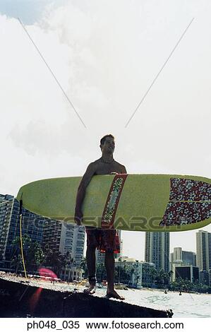 Young man at a platform, holding surfboard View Large Photo Image Stock Photography - Young man at a platform, holding surfboard . Fotosearch