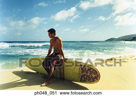 Young man sitting on surfboard View Large Photo Image Stock Image - Young man sitting on surfboard. Fotosearch