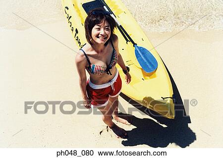 Stock Image - Young woman and kayak, elevated view. Fotosearch