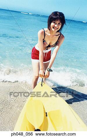 stock images of young woman pulling sea kayak into water ph048 056