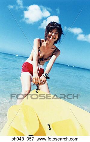 Young woman pulling sea kayak into water View Large Photo Image Stock Photo - Young woman pulling sea kayak into water . Fotosearch