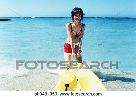 Young woman pulling sea kayak into water View Large Photo Image Stock Photo - Young woman pulling sea kayak into water . Fotosearch