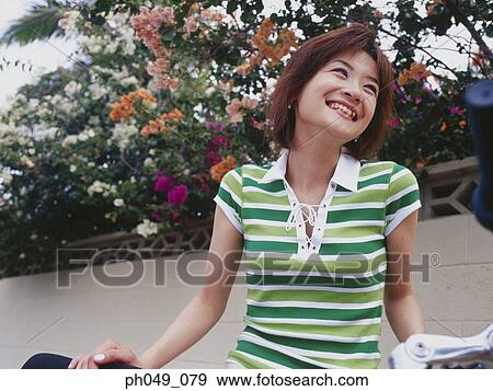 Stock Photo - Woman with bicycle, smiling. Fotosearch