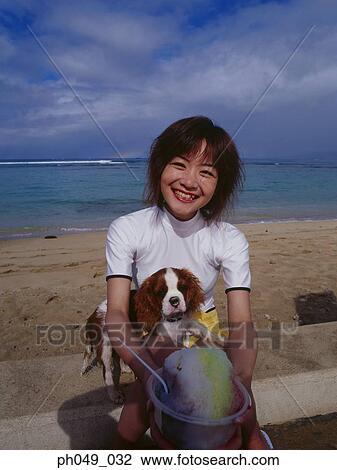 Stock Image - Young woman holding ice freeze and a puppy. Fotosearch