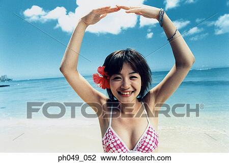 Young woman in bikini at a beach, arms stretched, portrait View Large Photo Image Stock Image - Young woman in bikini at a beach, arms stretched, portrait. Fotosearch