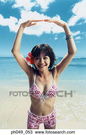 Young woman in bikini at a beach, arms stretched, portrait View Large Photo Image Stock Image - Young woman in bikini at a beach, arms stretched, portrait. Fotosearch