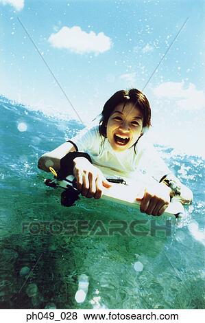 Young woman lying on paddleboard in ocean View Large Photo Image Stock Photo - Young woman lying on paddleboard in ocean. Fotosearch