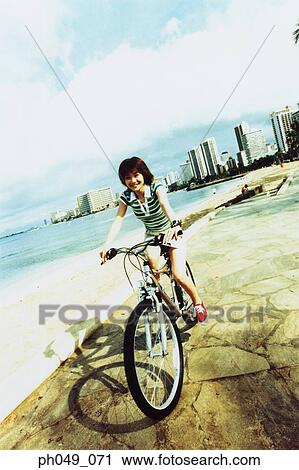 Young woman riding bicycle in the park View Large Photo Image Stock Image - Young woman riding bicycle in the park. Fotosearch