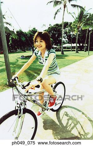 Young woman riding bicycle in the park View Large Photo Image Stock Photography - Young woman riding bicycle in the park. Fotosearch
