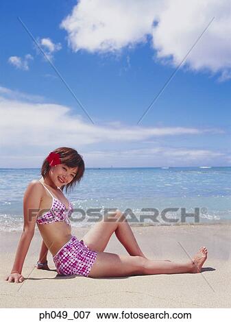Young woman seated on beach in pink bikini View Large Photo Image Stock Photo - Young woman seated on beach in pink bikini. Fotosearch