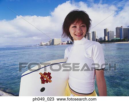 Stock Image - Young woman with paddleboard, portrait. Fotosearch