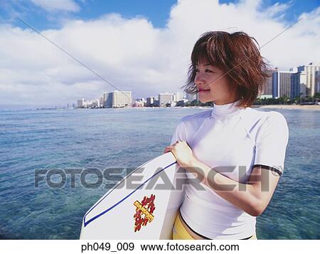 Stock Photo - Young woman with paddleboard, portrait. Fotosearch