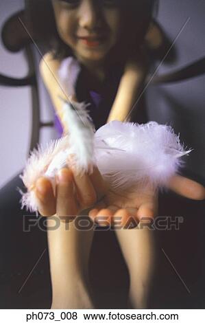 Stock Photo - Portrait of a girl holding feathers. Fotosearch