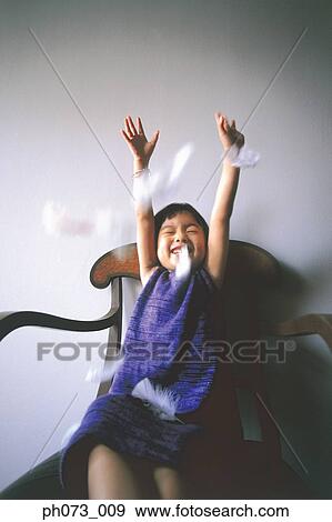 Stock Photo - Portrait of a girl stretching arms, falling feathers. Fotosearch