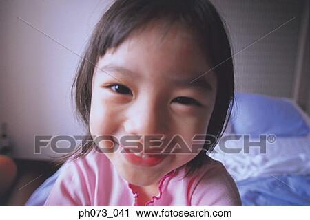 Stock Image - Portrait of a young girl smiling. Fotosearch
