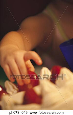 Young boy picking cherry from cake View Large Photo Image Stock Photograph - Young boy picking cherry from cake. Fotosearch