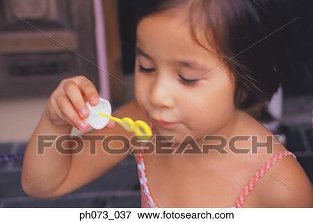 Stock Photo - Young girl blowing bubbles. Fotosearch